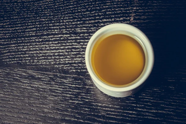 Tampa de azeite fresco numa mesa ou tábua de madeira preta. Tonificado — Fotografia de Stock