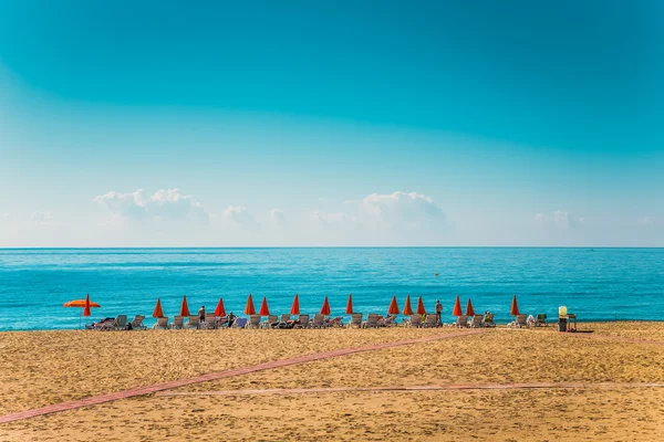Guarda-sóis de praia e espreguiçadeiras na praia em Alanya Turquia . — Fotografia de Stock