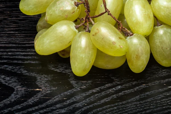 Raisin juteux frais mûr sur une table noire ou une planche comme fond — Photo