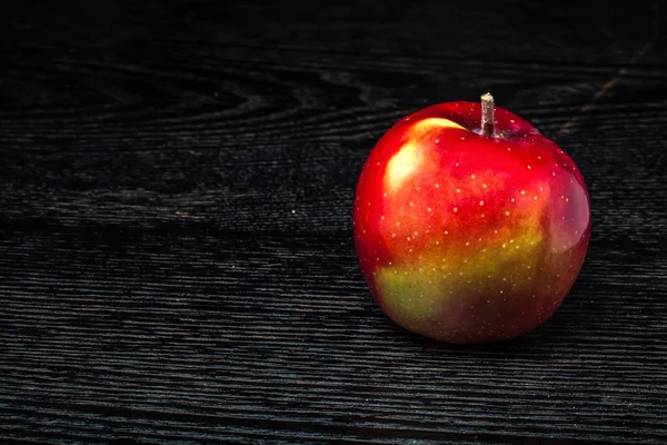 Zralé čerstvé šťavnaté jablko na černý stůl nebo deska jako pozadí — Stock fotografie