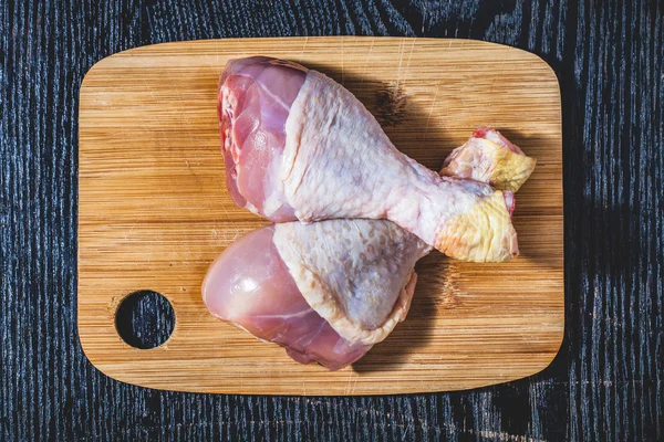 Pernas de chiken frescas em uma mesa preta ou placa como fundo. Tonelada — Fotografia de Stock