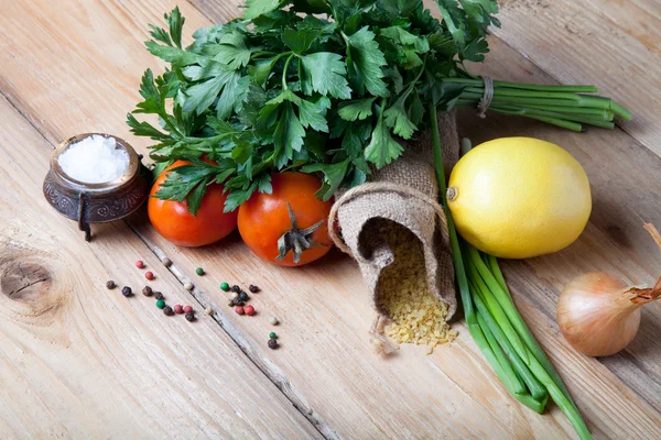 Groat derrama fora do saco e legumes e ervas em uma madeira — Fotografia de Stock