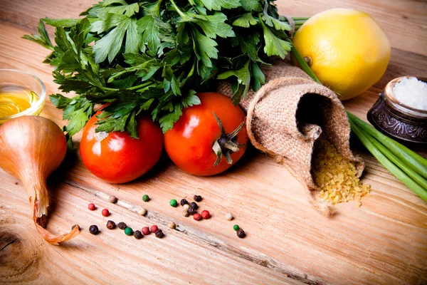 Groat derrama fora do saco e legumes e ervas em uma madeira — Fotografia de Stock