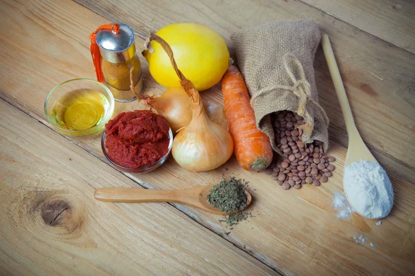 Groat pours out of the bag and vegetables and herbs on a wooden — Stock Photo, Image