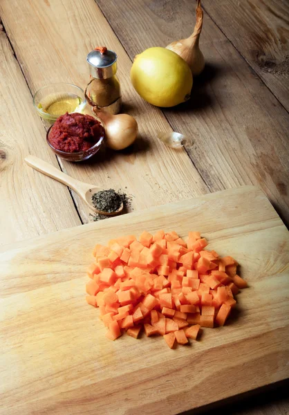 Fresh carrot with other vegetables and spices on a light wooden — Stock Photo, Image