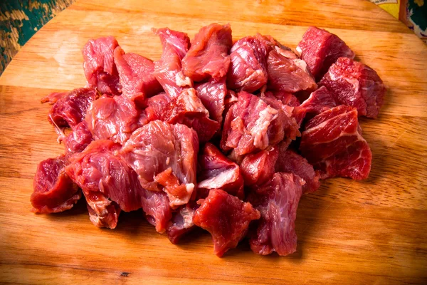 Carne fresca cruda sobre tabla de cortar ligera sobre una mesa de madera vieja. En —  Fotos de Stock