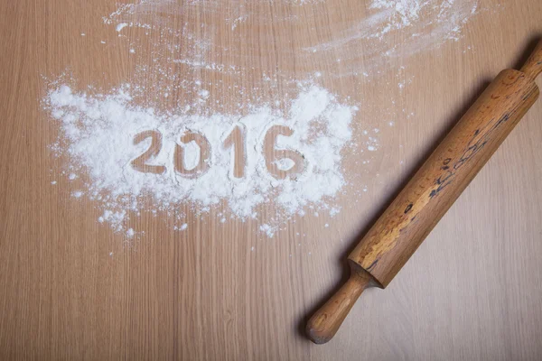 Figures 2016 on flour spilling on wooden background. Selective f — Stock Photo, Image