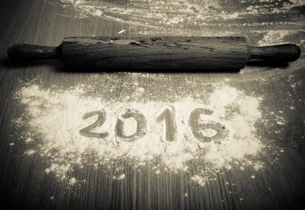 Figures 2016 on flour spilling on wooden background. Selective f — Stock Photo, Image