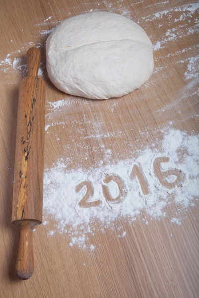 Figures 2016 on flour spilling on wooden background. Selective f — Stock Photo, Image