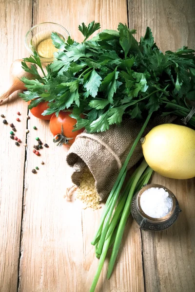 Groat pours out of the bag and vegetables and herbs on a wooden — Stock Photo, Image