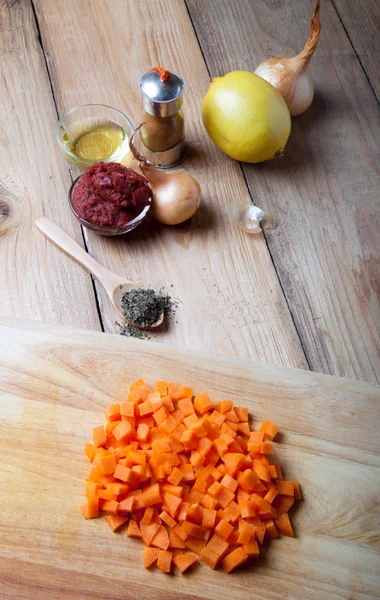 Fresh carrot with other vegetables and spices on a light wooden — Stock Photo, Image