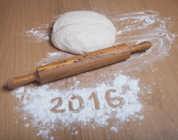 Figures 2016 on a flour on a light wooden table. Selective focus — Stock Photo, Image