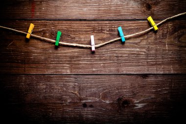 İp bir ahşap masa veya backg için tahta üzerinde renkli clothespins dönüştürün