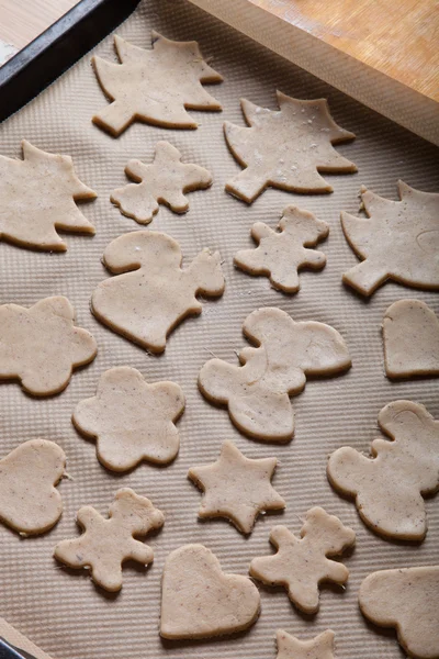 Gingerbread cookie in different shapes on light baking paper lik — Stockfoto