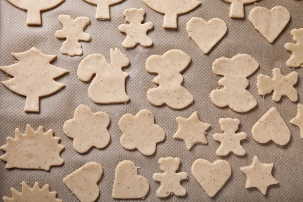 Gingerbread cookie in different shapes on light baking paper lik — Stockfoto