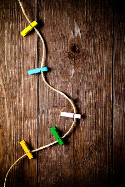 Цветные прищепки на веревке на деревянном столе или доске для спинки
