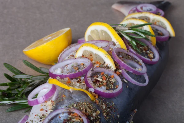 Fisk Nelma med citron, lök och rosmarin på ett träbord — Stockfoto