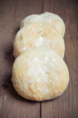 Koyu ahşap arka plan üzerinde küçük çörekler. Seçici odak. Tonda