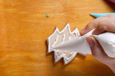 Yeni yıl gingerbread aşçı üzerinde çizim sürecinde kadının elleri