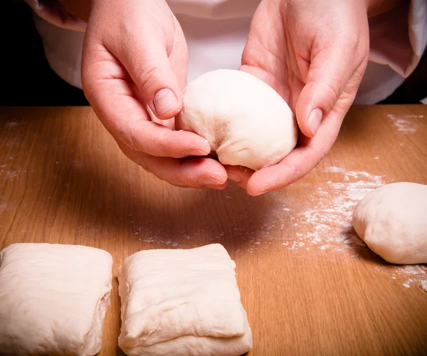 Female hands cut up dough. Selective focus. Toned