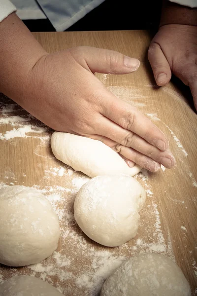 Female hands cut up dough. Selective focus. Toned — Stock Photo, Image