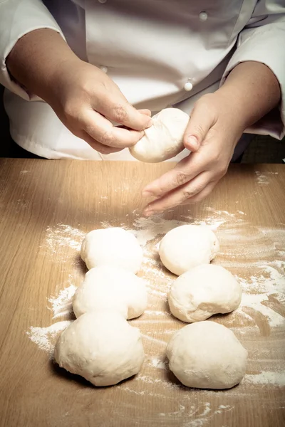 Female hands cut up dough. Selective focus. Toned — Stock Photo, Image