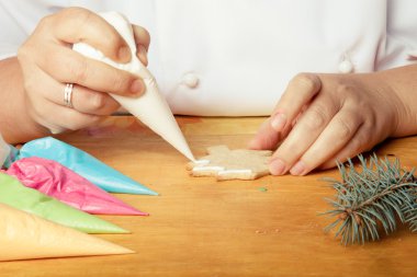 Yeni yıl gingerbread aşçı üzerinde çizim sürecinde kadının elleri