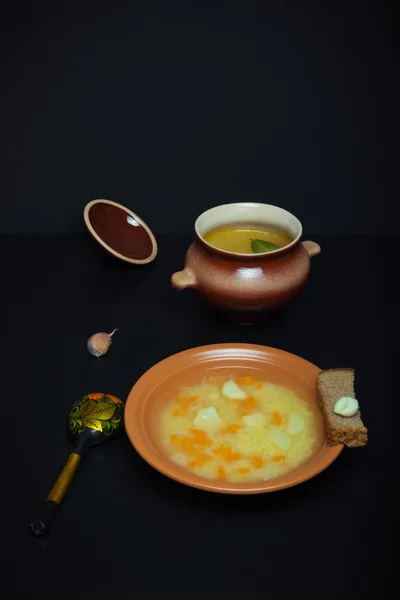 Soupe de riz dans une casserole d'argile sur une table ou un fond noir. tonique — Photo