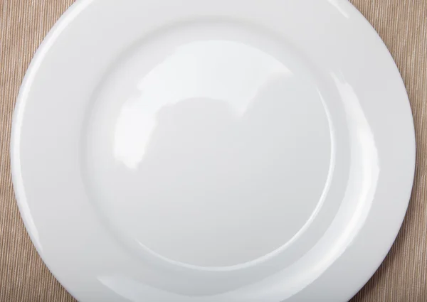 Empty white plate on grey napkin, top view — Stock Photo, Image