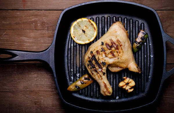 Chiken and vegetables on grill pan on old wooden table or board. — Stock Photo, Image