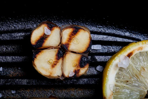 Чеснок и лимон на сковороде — стоковое фото