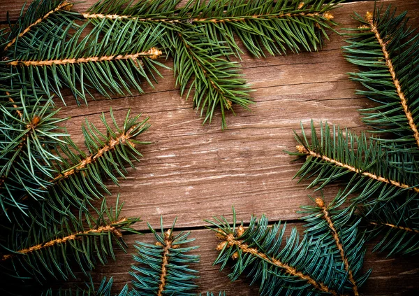 Christmas tree branch on a wooden table or board for background. — Stock Photo, Image