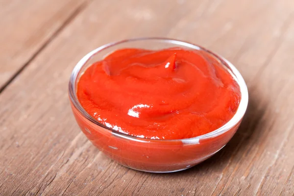 Ketchup de tomate servido em uma tigela de vidro pequena na antiga ta de madeira — Fotografia de Stock