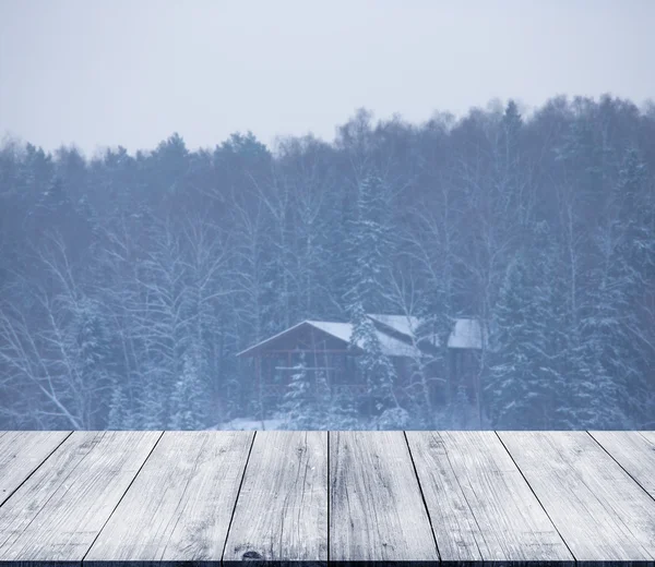 Utsikt över hus i snörik vinter skog från mörkt trä Landgången, t — Stockfoto