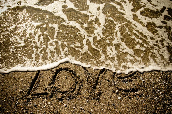 The inscription "LOVE" on a wet sand seacoast. Toned — Stock Photo, Image