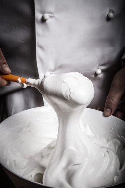 Çırpılmış yumurta akı bir beyaz seramik kase hamur işi için. Tonda