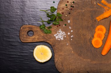 Sebzeler, otlar ve baharatlar siyah adam üzerinde kesme tahtası üzerinde