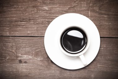 Beyaz fincan kahve eski ahşap masa üzerinde. Tonda