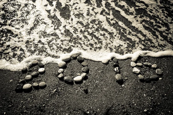 L'iscrizione "2016" di piccolo ciottolo su una spiaggia di sabbia bagnata. T — Foto Stock