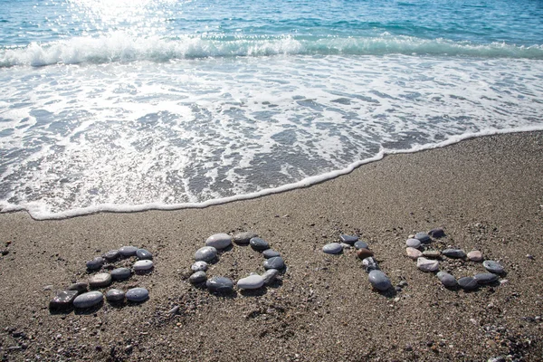 Надпись "2016" мелким камешком на мокром песчаном побережье — стоковое фото