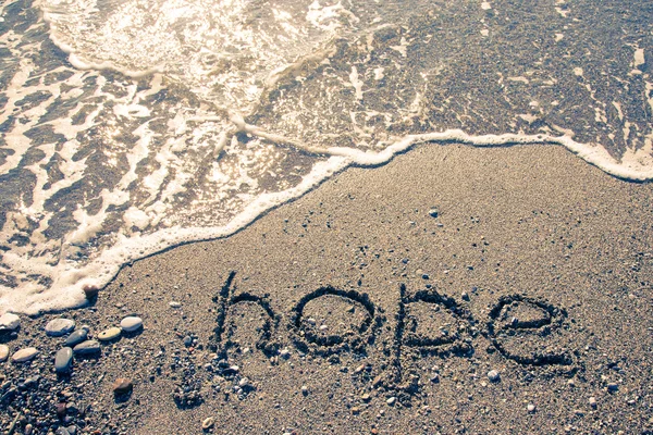 湿った砂の海岸に刻まれた"HOPE" 。トーン — ストック写真