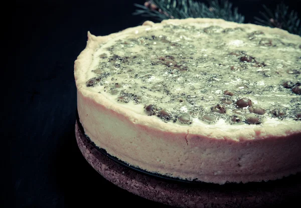 Torta com recheio com galhos de árvore de Natal em um backgro preto — Fotografia de Stock