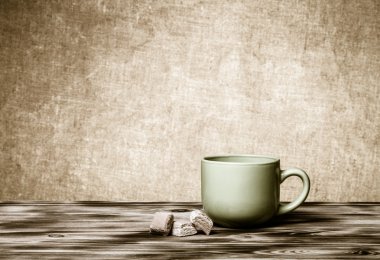 Fincan çay yeni ahşap tahta ve çuval bezi arka plan üzerinde. Tonda