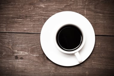 Beyaz fincan kahve eski ahşap masa üzerinde. Tonda