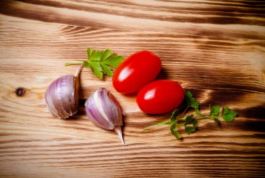 Herbs and vegetables on a new burned wooden background. Toned