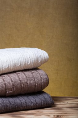 Ahşap tablo karşısında ufuk bu örme elbise yığını