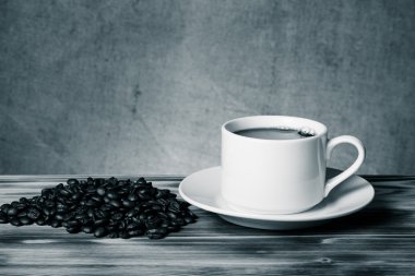 Kahve çekirdekleri ve ahşap masa ters beyaz fincan kahve bir 