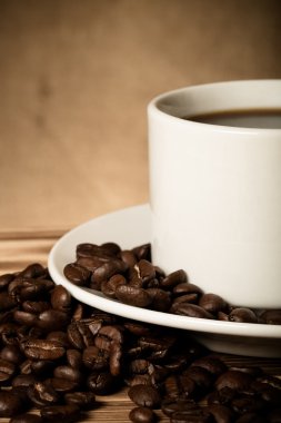 Kahve çekirdekleri ve ahşap masa ters beyaz fincan kahve bir 