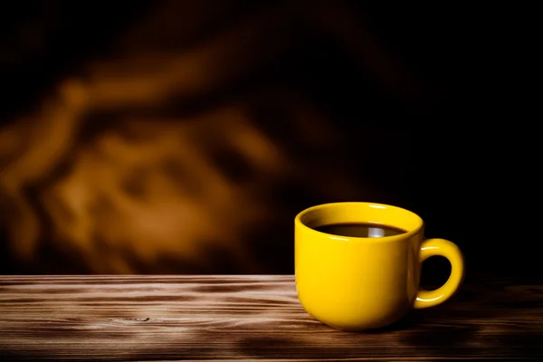 Coffee in cup on wooden table opposite a blurred background. Ton — Stock Photo, Image