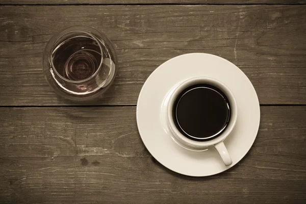 White cup of coffee and cognac in a glass on old wooden table. T — Stock Photo, Image